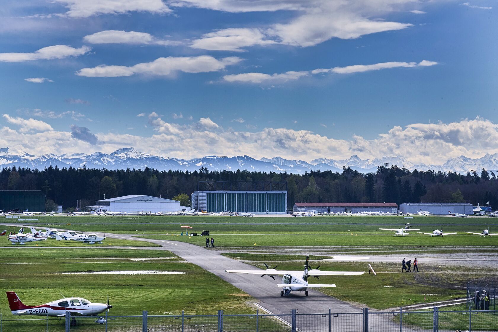 Visiting aircraft parked at Friedrichshafen airfield with the Alps behind